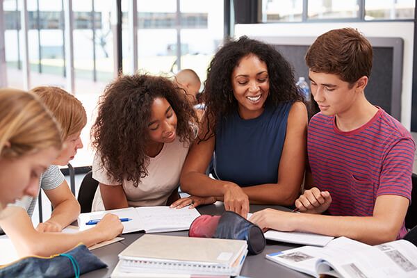 A female Spanish teacher providing differentiated instruction to her middle school students.