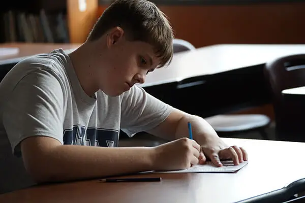 A Millcreek Township School District student sits at his desk focusing on a math problem.