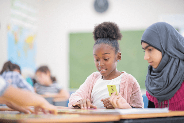 Photograph of two middle school students working on a literacy project together.
