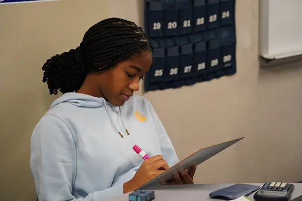 A Millcreek Township School District student sits at her desk focusing on a math problem.