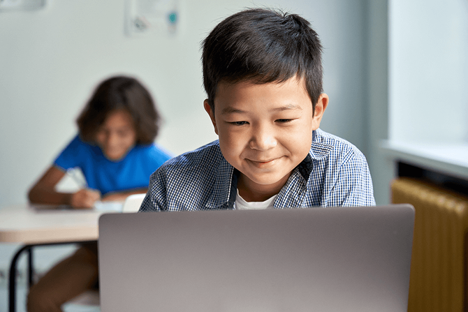 boy doing school work on laptop