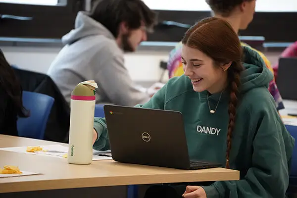 A Millcreek Township School District student sits happily at her desk working on a math problem