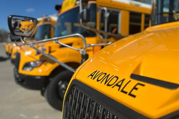 Photo of Avondale School District buses lined up in Auburn Hills, MI with the word “AVONDALE” across one of the bus hoods.