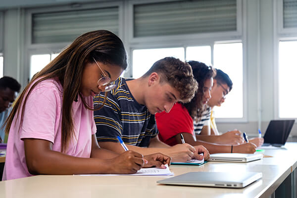 High school students concentrating on a writing assignment in the classroom.