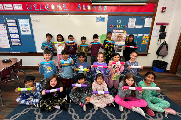 An image of Monroe Township School District students holding up time capsules they worked as part of a myView Literacy lesson.