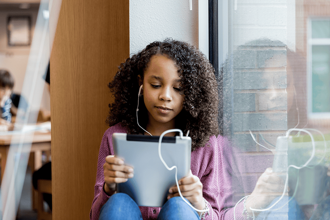 middle school student reading on a tablet computer