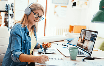 02-fresh-ideas-teacher-on-headphones-while-working-at-desk-337x214.png