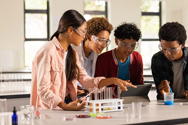 Middle school students and their teacher conducting a three-dimensional learning experiment.