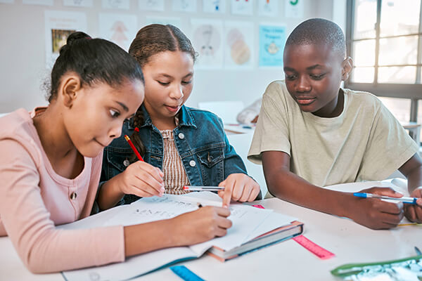 Students working together in a group at a table on a math modeling lesson.