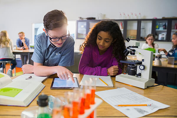 Photo of two students having a purposeful discussion with each other in a science classroom.
