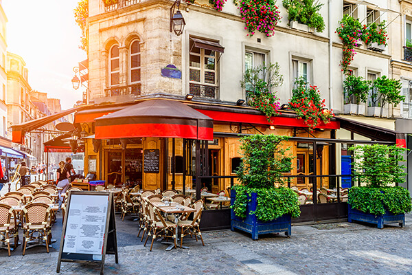 A photo of a cozy street with cafe tables in Paris, France.