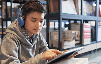04-middle-grade-student-reading-tablet-with-headphones-on-337x214.png