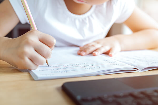 A teacher writing on a whiteboard teaching a lesson about sentence structure.