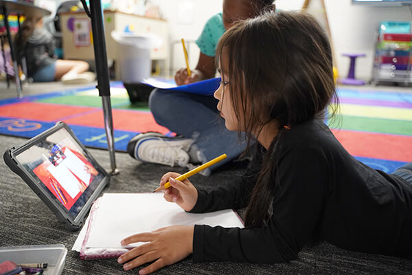 A young student practicing reading and writing skills using myView Literacy from Savvas Learning Company