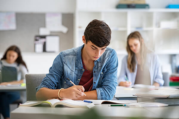 An older student sitting at his desk working on a literacy activity.