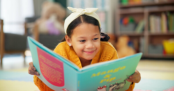 Young student happily reading a book with confidence at school.
